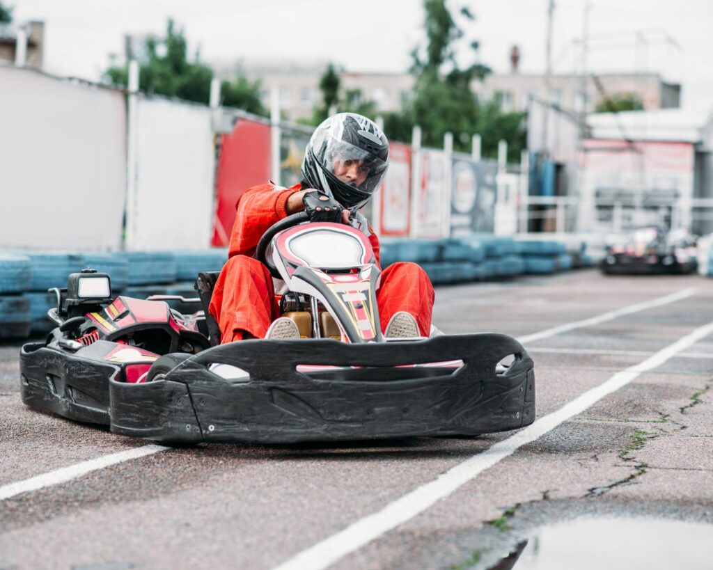 Jeune homme dans un kart, sur un circuit de karting