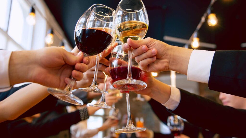 Groupe de personnes qui trinque avec leurs verres de vin 